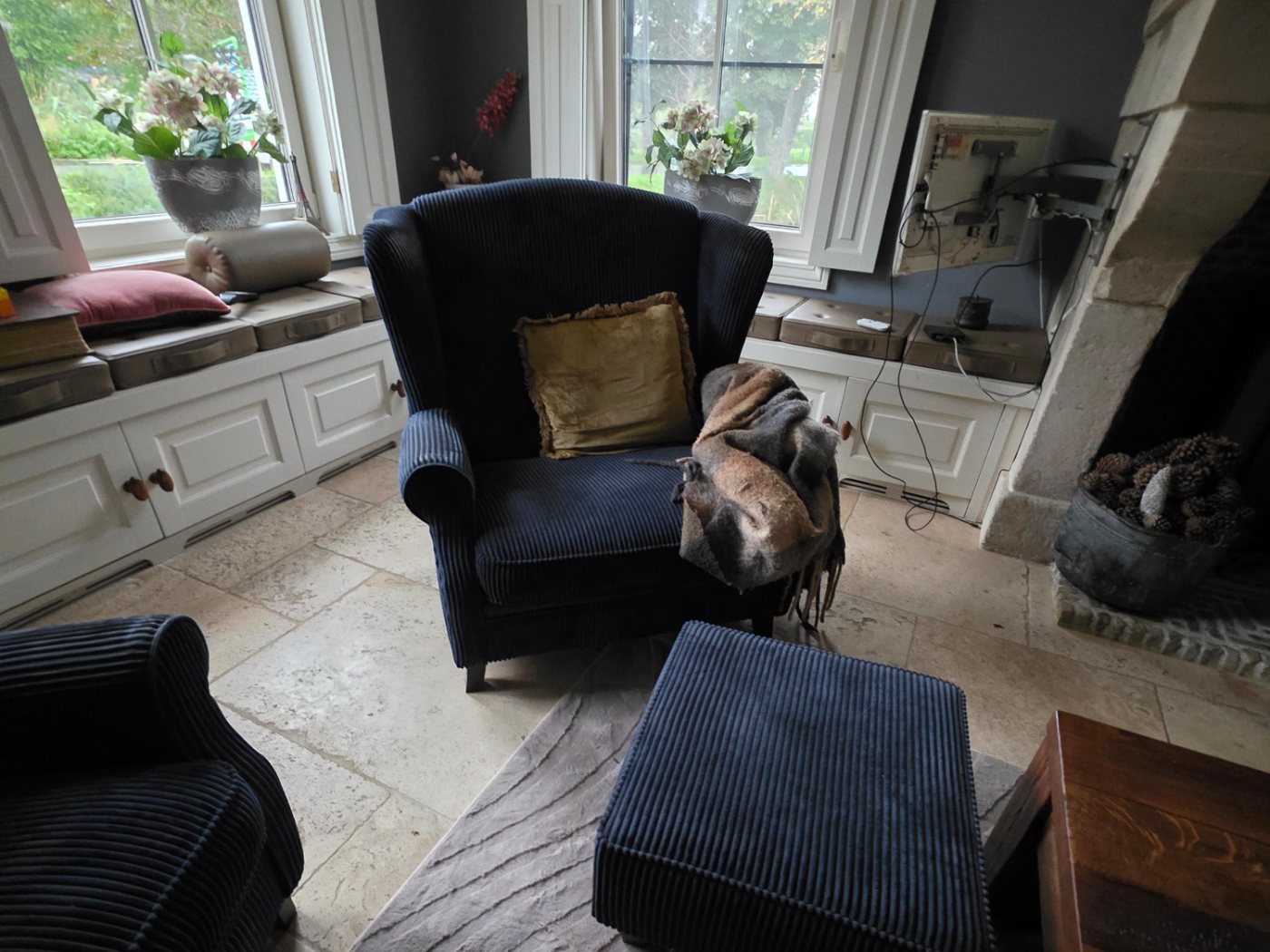 Oorfauteuil met hocker in donkerblauw corduroy voor het herstofferen
