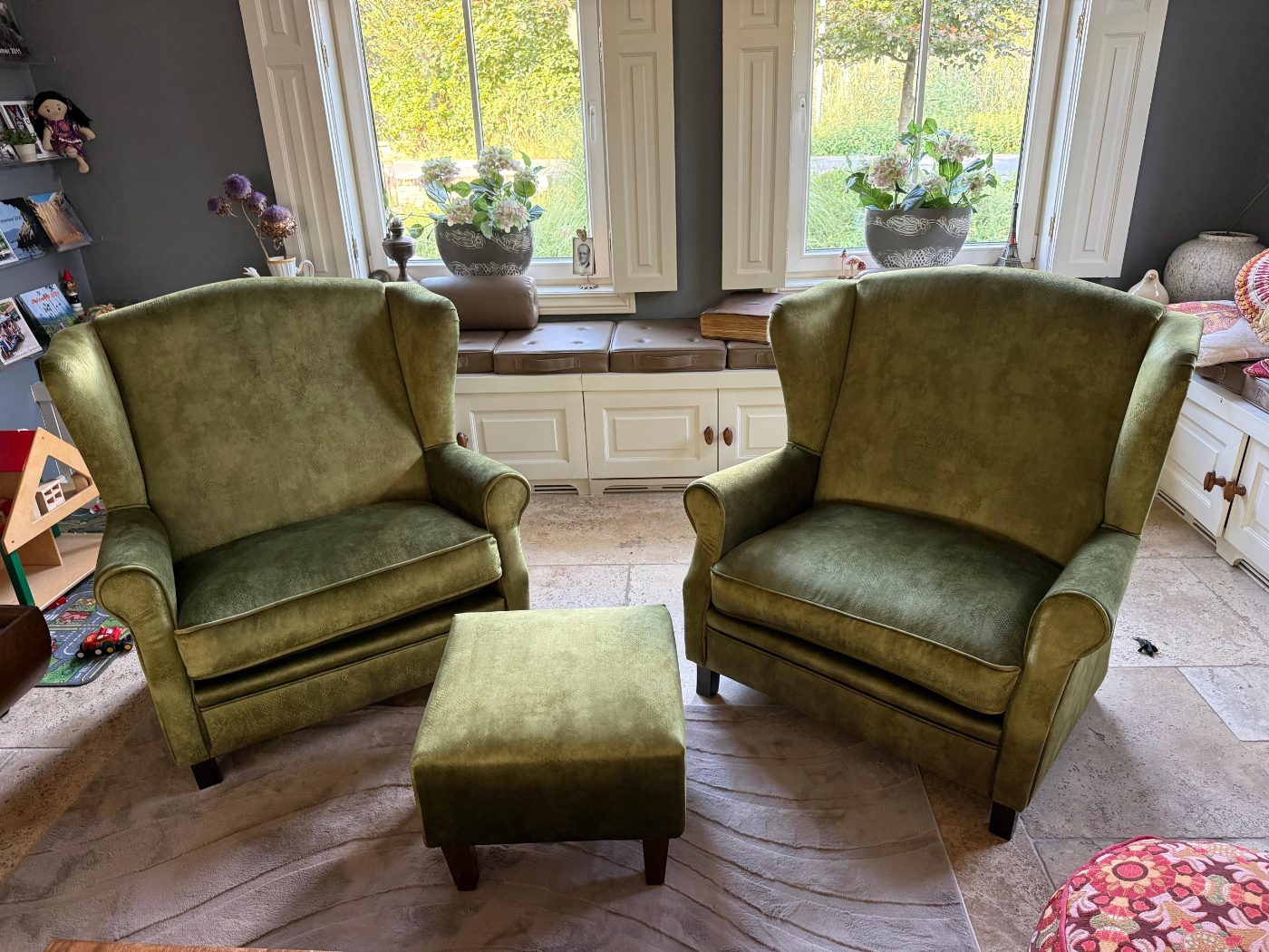 Twee oorfauteuils met hocker opnieuw gestoffeerd in groene velours